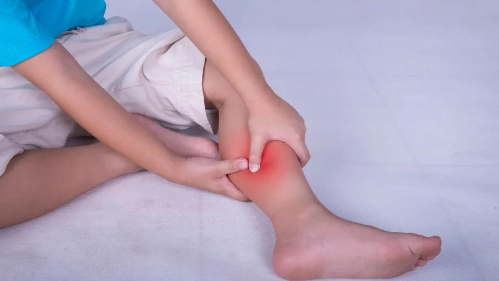 Person holding their lower leg in pain, with a red-highlighted area indicating discomfort or injury.