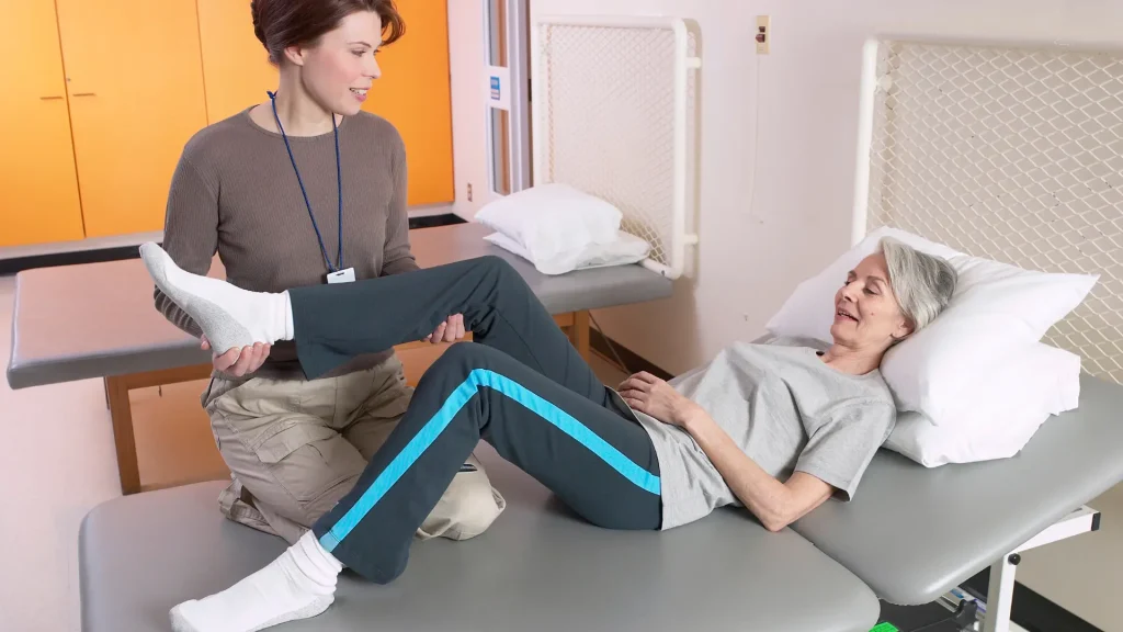 Physical therapist assisting a patient with leg exercises